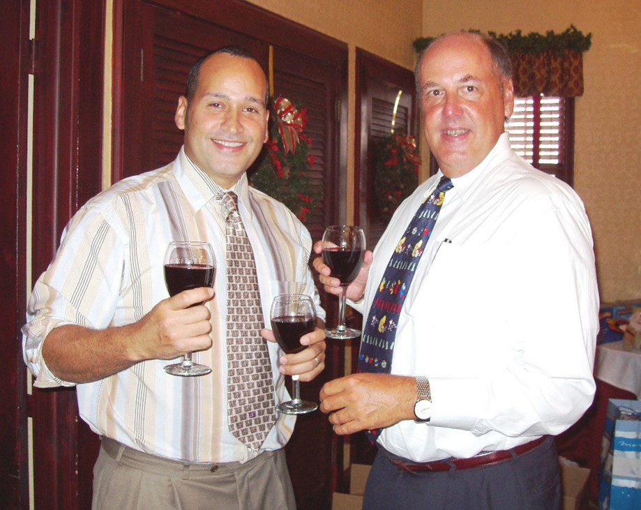 terry A photo of Luis Guzman and Terry Griffin holding wine glasses at a holiday party